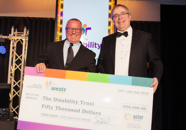 Chairperson Trevor handing a cheque at The Disability Trust Gala in 2016.